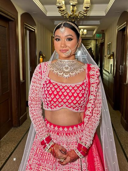 The full bridal look, complete with a sheer veil and a traditional nath. The smokey eyes add a touch of drama and sophistication.