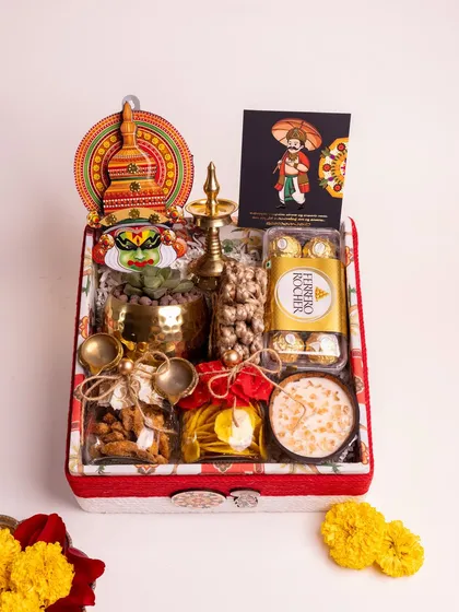 My 'Ponnonam' luxury hamper is a celebration of Onam in a box. It's filled with traditional delights like sharkara varatti and upperi, alongside Ferrero Rocher, a live succulent, and cultural symbols like a Kathakali head and a brass nilavilakku, all presented in a beautifully lined custom box.