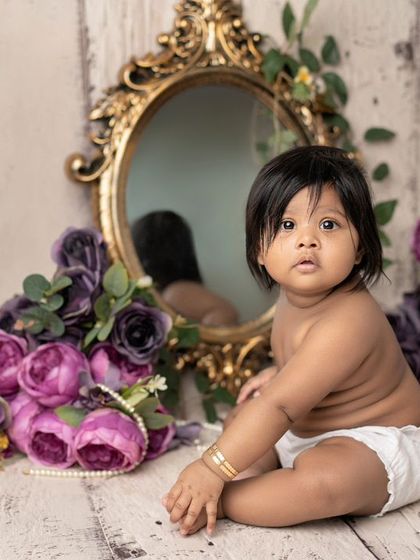 A beautiful sitter session with a vintage feel. The mirror and purple flowers create a unique and artistic portrait.