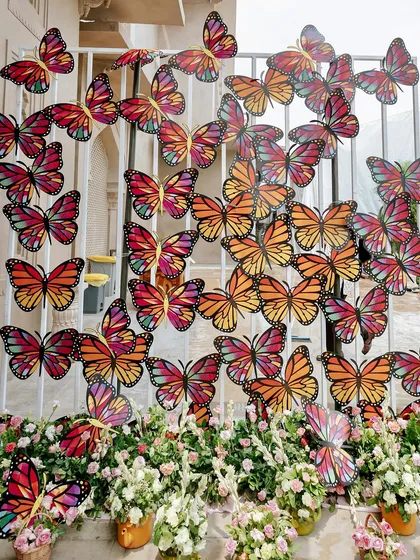A stunning butterfly wall created as a unique photo backdrop, adding a vibrant and artistic element to the spring-themed Mehendi decor.