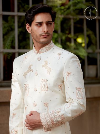 A detailed shot of the unique embroidery on this off-white sherwani. The horse motifs add a touch of personality and charm, making it a memorable choice for a groom's wedding attire.