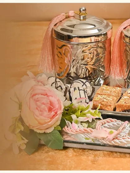A closer look at the 'Afreen' wedding hamper. I love using elegant silver-plated jars with pink tassels and pairing them with fresh florals and delicious sweets on a mirrored tray.