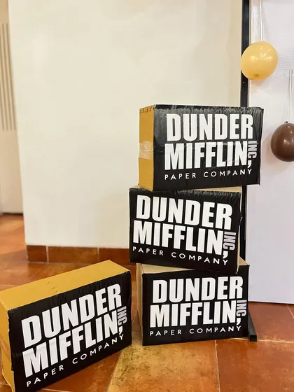 A close-up of the custom-made Dunder Mifflin Paper Company boxes. These props were essential in transforming the space and making the theme feel authentic for the birthday celebration.
