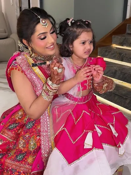 A beautiful moment between a mother and her daughter during a Mata Ki Chowki. The rose pink glam complements the vibrant outfits perfectly.