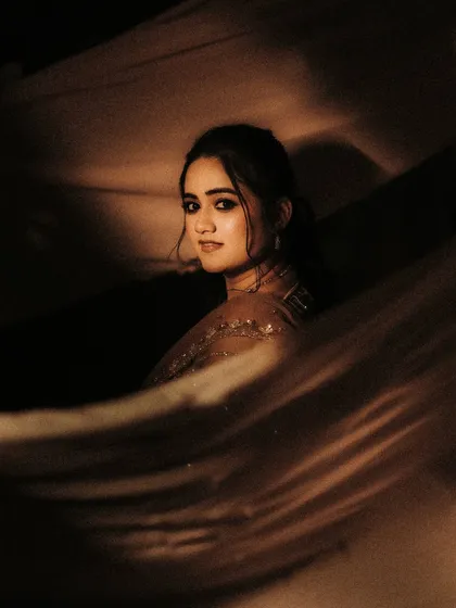 A moody and beautiful portrait using flowing fabric. The play of light and shadow, combined with the bride's soft expression, creates an image that feels like a painting.