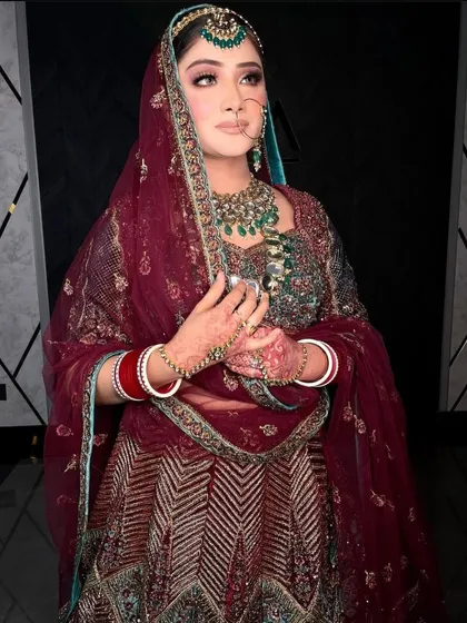 A full shot of the bride, showcasing her magnificent lehenga and the way the jewellery complements the deep, rich colors.