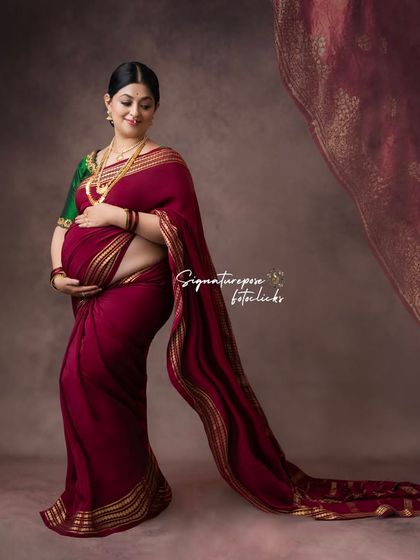 A side profile shot that beautifully showcases the baby bump, with the saree elegantly draped.
