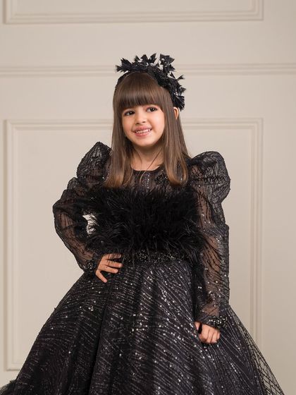 A closer look at the luxurious feather and sequin detailing on the bodice of our black ball gown.