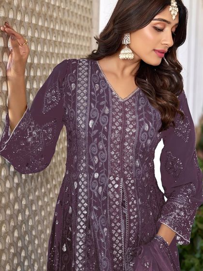 A stunning purple Anarkali with intricate thread, zari, and sequence work. The flowing silhouette and rich color make it a perfect choice for a sangeet or reception.