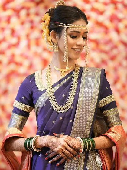 Elegance personified. This bride's traditional look in a purple Nauvari saree is enhanced with subtle makeup and classic Maharashtrian jewelry.