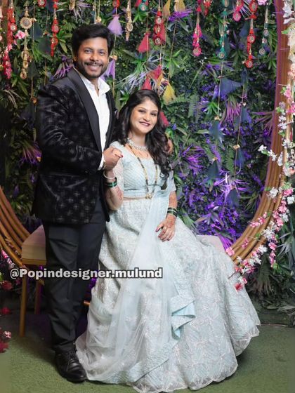 A beautiful shot of the couple seated, showcasing the intricate embroidery of her gown and the sharp tailoring of his tuxedo.
