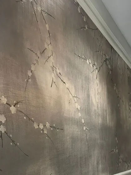 A close-up of the hand-painted, silver-leafed wallpaper used in the jewelry store project. The delicate cherry blossoms and shimmering background exude a timeless elegance that enhances the luxury of the space.
