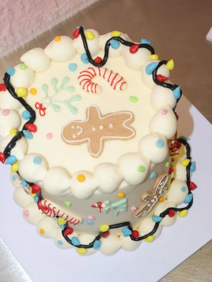 It's beginning to look a lot like Christmas with this festive cake, decorated with a gingerbread man, candy canes, and colorful string lights.