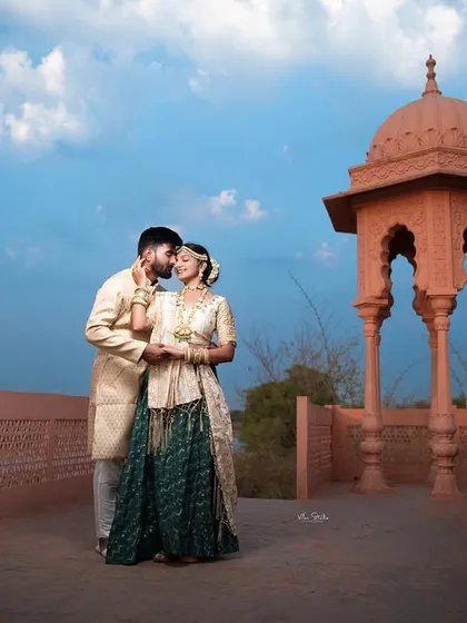 A romantic moment on the terrace, with the groom-to-be leaning in for a kiss. The beautiful architecture and open sky create a perfect backdrop for this love story.