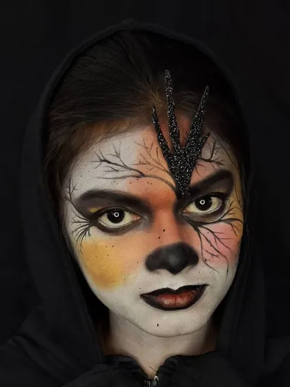 A direct, intense stare captures the full power of this gothic character makeup. The combination of the dark lips, piercing white eyes, and intricate line work creates a memorable, haunting image.