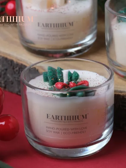 A close-up of one of the Christmas jar candles, showing the tiny tree and holly details.