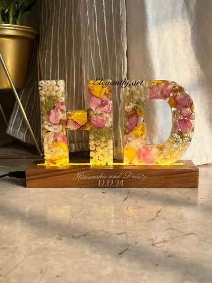 Another view of the custom "HD" monogram LED lamp, glowing warmly. It’s a perfect way to preserve wedding garlands, proposal bouquets, or any special flowers close to your heart.