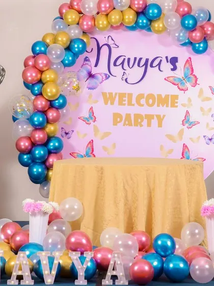 An elegant butterfly "Welcome Party" setup with beautiful balloon columns and personalized lettering.