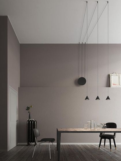 A multi-pendant Filomena installation over a dining table, its minimalist design allowing the focus to remain on the room's architecture and furnishings.