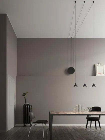 A cluster of Filomena pendants hung from a single point, creating a simple yet effective chandelier over a modern dining table. The design allows for endless creativity.