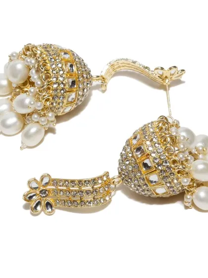 A detailed shot of the pearl kundan jhumkas, highlighting the quality of the pearls and the sparkle of the stones.