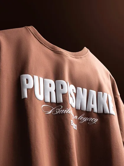 Another angle of the brown t-shirt, using lighting to create depth and highlight the texture of the fabric and the raised lettering. This adds a premium feel to a simple product.
