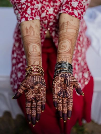 This custom design for a beautiful bride features portraits of her and her groom, along with their initials and symbols of their journey, like the Mysore Palace and the Golden Gate Bridge.