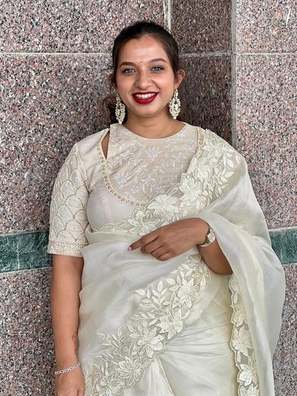 A client looking beautiful in a white organza saree with floral embroidery. I created a matching white blouse with a unique neckline to complete the angelic look.
