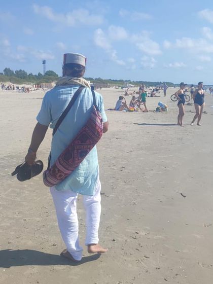 Walking on a beach, with my yoga mat slung over my shoulder. Yoga can be practiced anywhere, from the mountains to the sea.