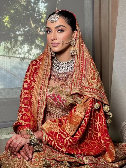 A beautiful bride styled in a traditional red and gold Rimple & Harpreet lehenga. I focused on the double dupatta draping to add layers and grandeur, creating a look inspired by heritage and royalty.