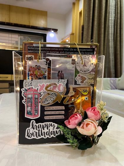 Your search for the perfect gift for your husband ends here. This acrylic tote hamper includes a handmade card, a vintage-style glass frame, and other custom goodies, all lit up with fairy lights.