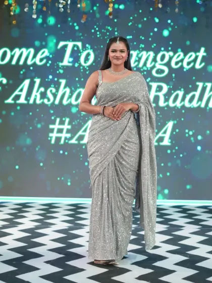 A formal pose in my silver saree in front of the Sangeet night welcome screen.