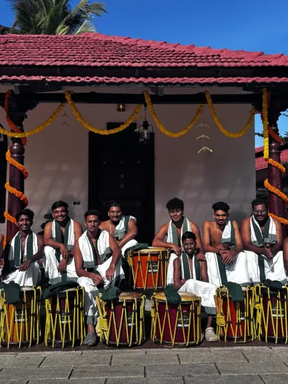 Our team posing in front of a traditional Kerala-style house. We are proud of our roots and bring that cultural heritage to our performances in Bangalore.