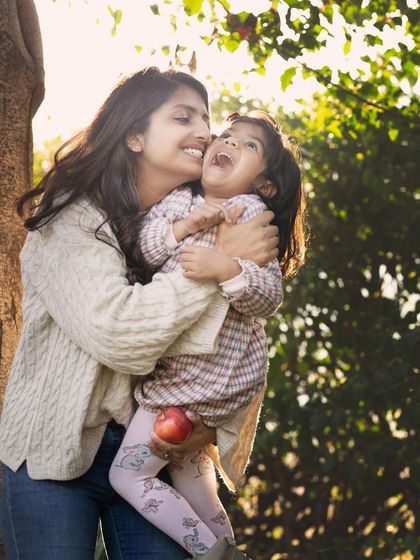 A tickle, a laugh, and a whole lot of love. This candid mother-daughter moment, bathed in beautiful natural light, is what makes outdoor family photography so special.