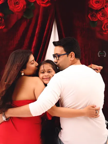A moment of pure family love. Both parents kiss their daughter's cheeks in this heartwarming photo from their Valentine's family and maternity session.