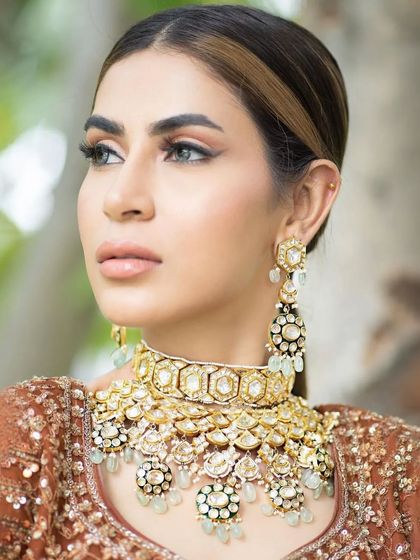 A minimal bridal look perfect for a day wedding. The makeup focuses on a soft base, nude glossy lips, and sleek hairstyling, creating a look that is chic, modern, and effortlessly elegant.