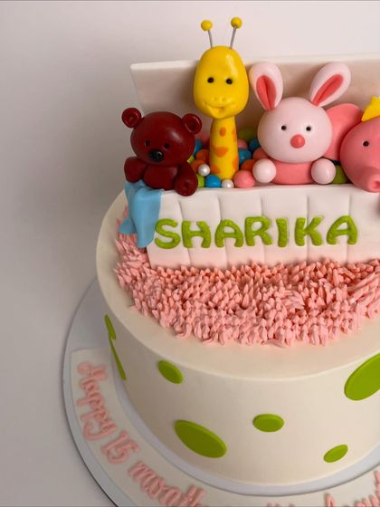 A detailed shot of the toy box cake, focusing on the adorable, handcrafted animal toppers peeking out.