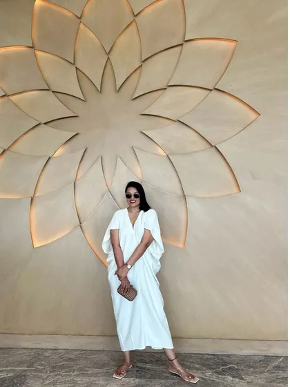 The same white kaftan, styled with a classic clutch. It's a look that is both minimalist and incredibly chic.