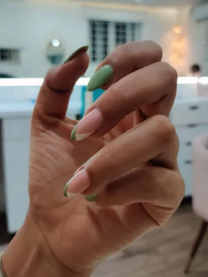 Some subtle, everyday nails for a corporate client. This design features a mix of solid pastel green and a modern French tip design.