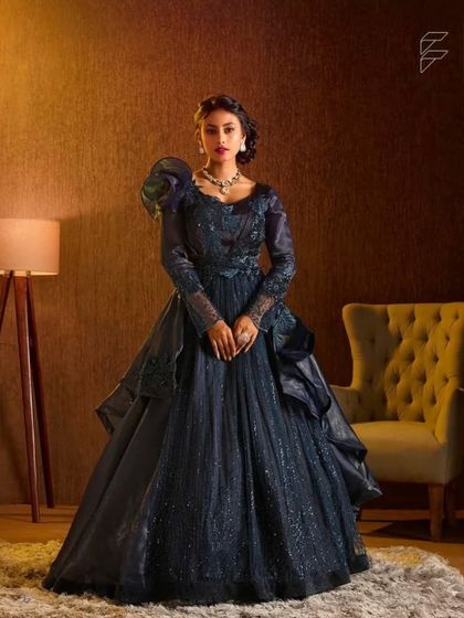 Experience the latest designer trends with this dark navy blue gown. The dramatic puff sleeves and intricate detailing offer a high fashion look for your event.