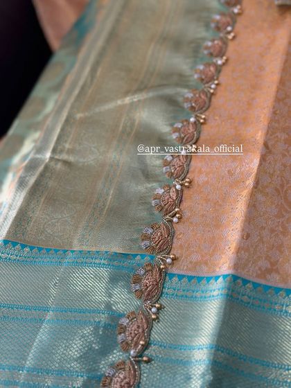 A scalloped saree border with delicate embroidery.