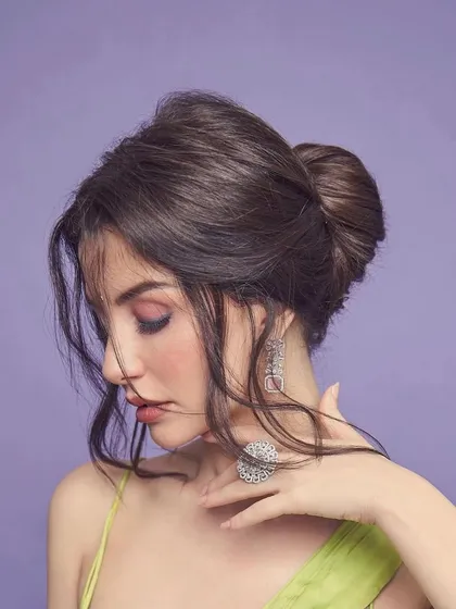 A festive and soft updo with wispy tendrils, created for a photoshoot.