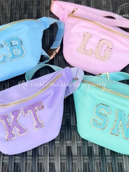 Our new pastel fanny packs are perfect for your girl gang. Available in soft shades of blue, pink, purple, and mint, these waist pouches can be customized with glittery initial patches.