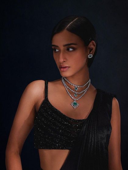 A sophisticated look for Purab Paschim, showcasing a triple-layered emerald and diamond necklace with matching studs.