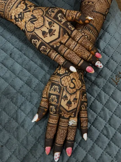 The other hand of the same design, featuring the groom's initial 'S' and intricate patterns. The matching yet unique designs for each hand create a cohesive look.