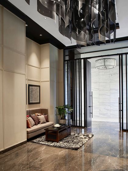 The entrance lobby features a comfortable seating nook with custom graphics, set against white veneer paneled walls and a polished marble floor.