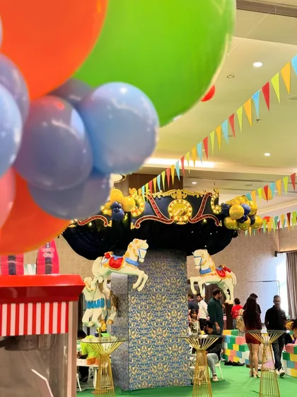 A Central Park-themed first birthday featuring a stunning carousel centerpiece, a candy floss cart, and a large pastel-colored soft play area for endless fun.