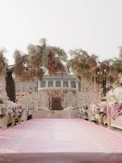 The view down the aisle towards the magnificent pink-themed mandap. We design the processional path to build anticipation and create a stunning visual journey for the bride and guests.