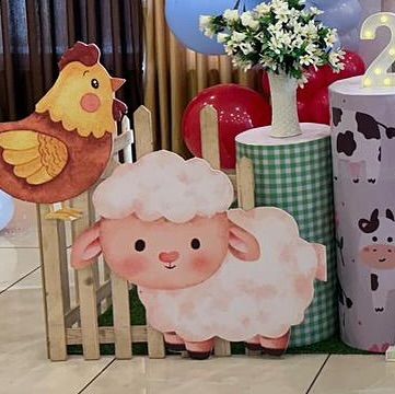 A cute sheep and chicken cutout next to a gingham-patterned plinth. Every element is carefully chosen to match the farm animal theme.