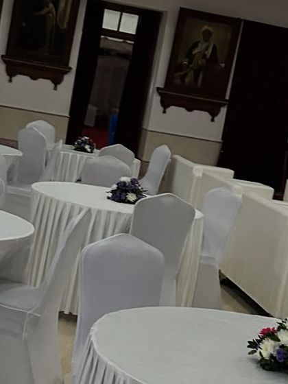 We manage all aspects of event seating and layout. This image shows the combination of lounge sofas and classic round tables with white linens and simple floral centerpieces for attendees.